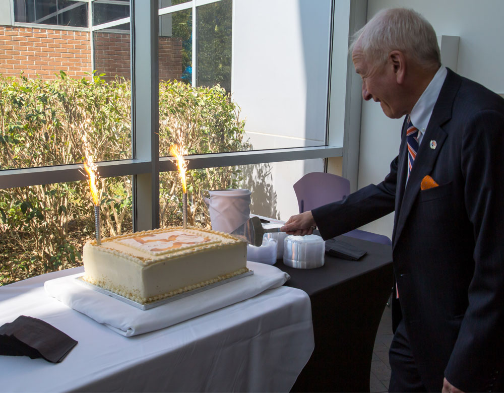 University president cutting cake