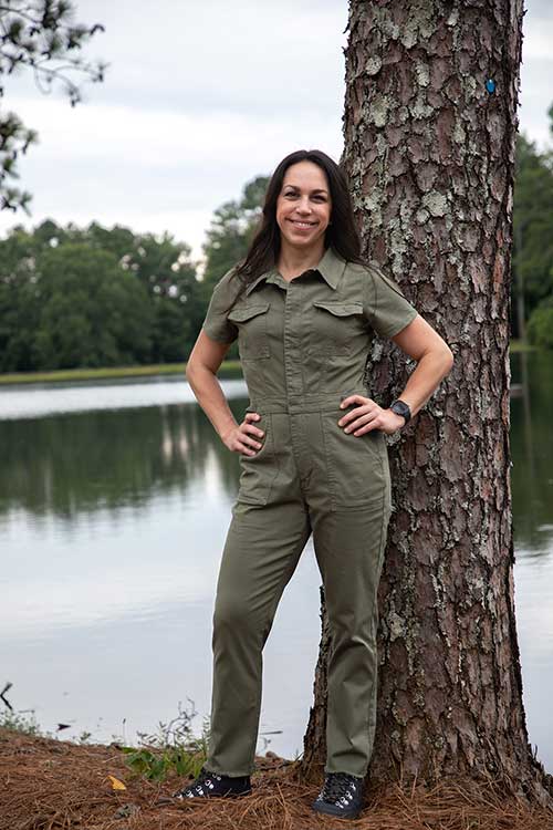 andrea allen leaning on a tree next to a lake