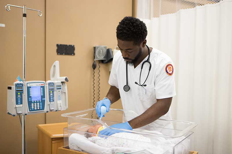 Student in sim lap with baby