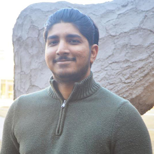 Image of Jay Patel wearing a green quarter-zip sweater