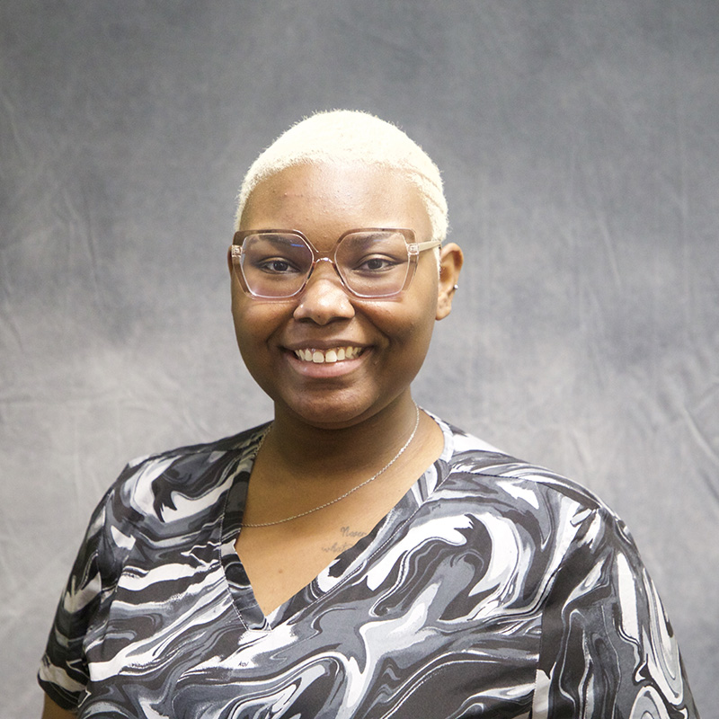 Image of Cammiah Olinde wearing a black top with gray and white swirls and glasses