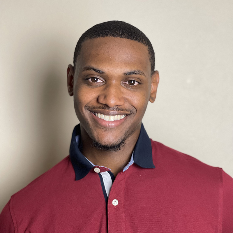 Image of James McKinney, wearing a red polo-style shirt
