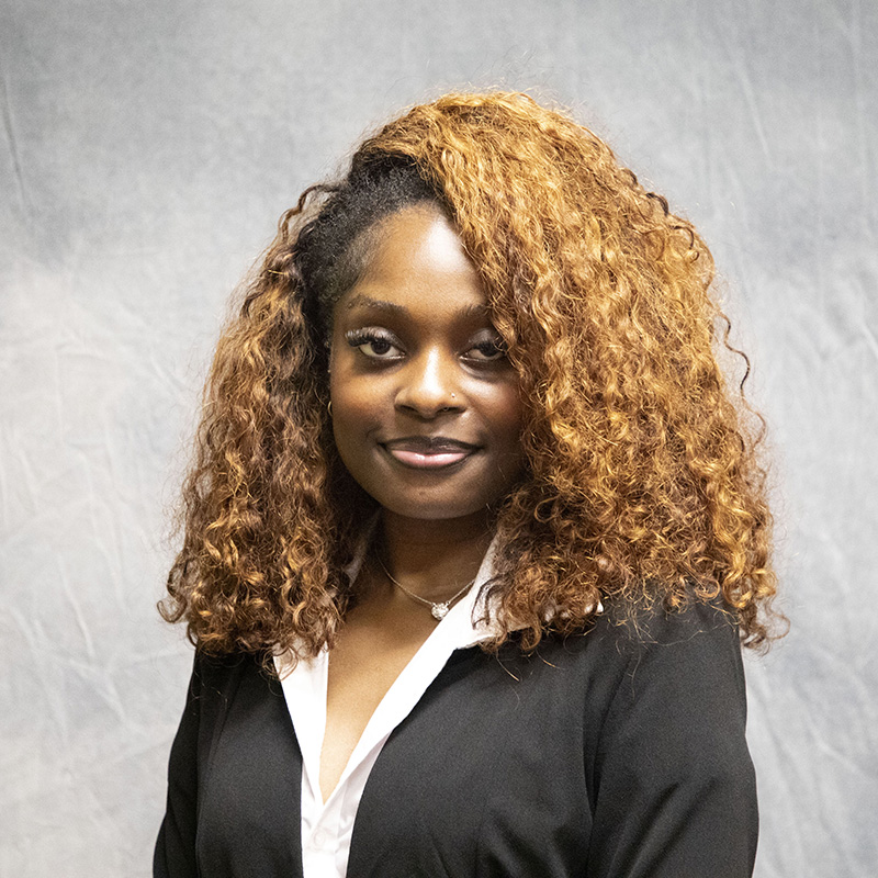 Image of Sha'Niya Dilworth wearing a white button-up shirt and a blazer. 