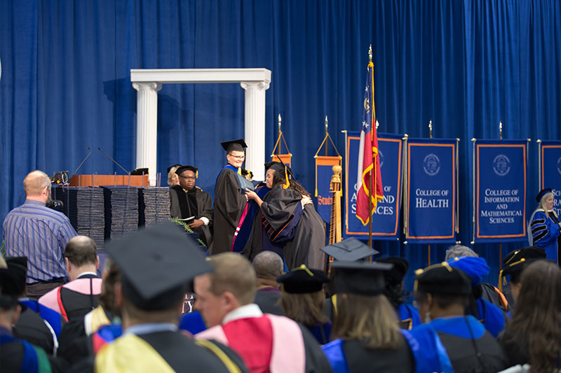 Graduate hugging President