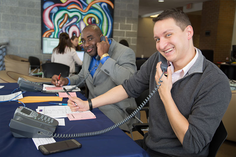 Employees on the phone smiling for camera