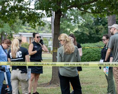 Dr. Andrea speaking to group at crime scene