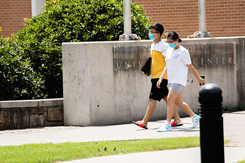 Students walking on campus wearing masks