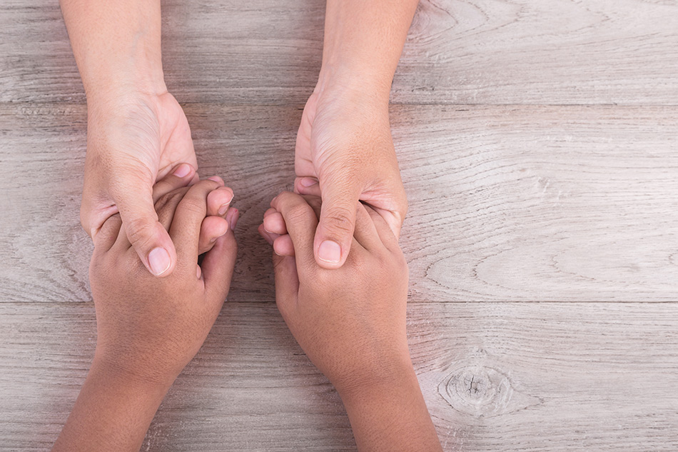 Adult holding hands with a child.