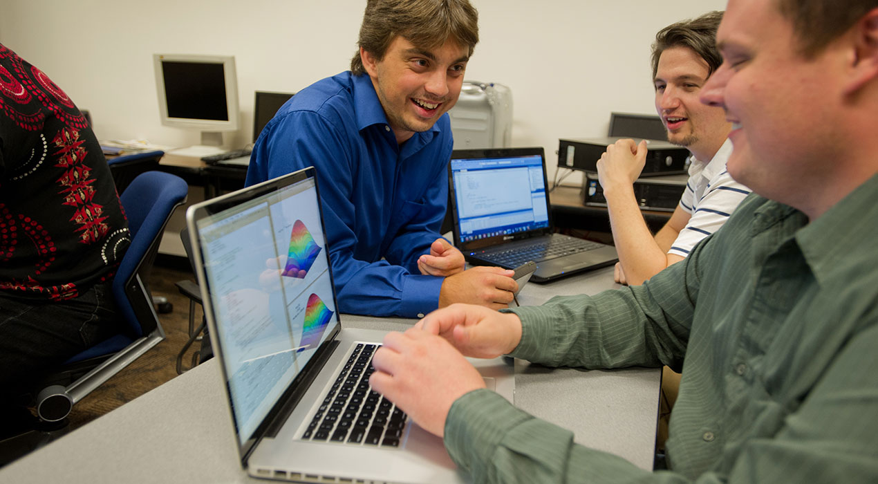 Students around a lap top