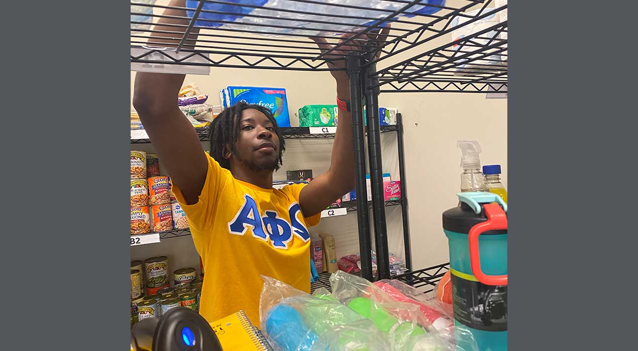 Junior Jakori Watson helps stock items at the Laker Care Pantry